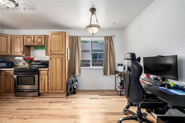 1013 Maxwell St, Colorado Springs, CO 80906 - kitchen featuring gas range, black microwave, light wood-style floors, a desk, and hanging light fixtures