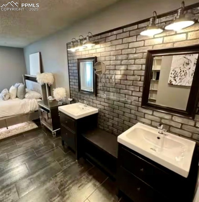 4110 Novia Dr, Colorado Springs, CO 80911 - full bath with two vanities, a textured ceiling, and brick wall