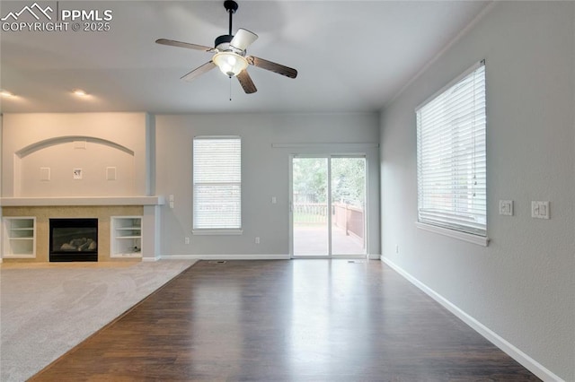 3355 Willowrun Dr, Castle Rock, CO 80109 - unfurnished living room with a ceiling fan, a fireplace, wood finished floors, and built in features