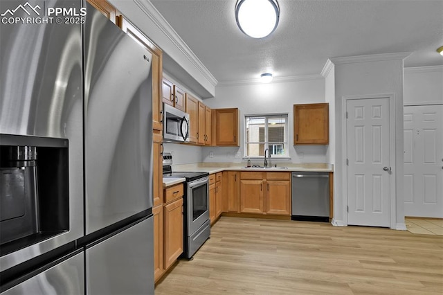 4888 Kerry Lynn Way Unit 101, Colorado Springs, CO 80922 - kitchen featuring appliances with stainless steel finishes, ornamental molding, a textured ceiling, light countertops, and light wood-type flooring