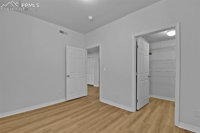 4888 Kerry Lynn Way Unit 101, Colorado Springs, CO 80922 - unfurnished bedroom featuring light wood-type flooring, a spacious closet, and a closet