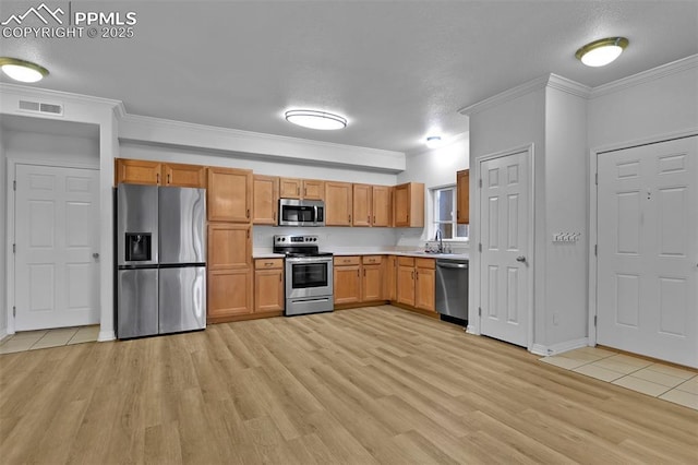 4888 Kerry Lynn Way Unit 101, Colorado Springs, CO 80922 - kitchen featuring appliances with stainless steel finishes, light wood-type flooring, light countertops, ornamental molding, and brown cabinets