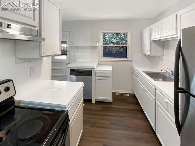 307 Mount View Ln, Fountain, CO 80817 - kitchen featuring stainless steel appliances, wall chimney range hood, healthy amount of natural light, and white cabinetry