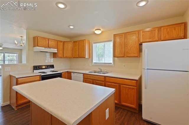 4400 Rawhide Rd Unit 157, Pueblo, CO 81008 - kitchen featuring white appliances, dark wood-style floors, under cabinet range hood, light countertops, and decorative backsplash