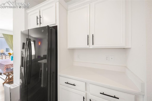 16423 Mountain Flax Dr, Monument, CO 80132 - kitchen with black refrigerator with ice dispenser, white cabinetry, and light countertops