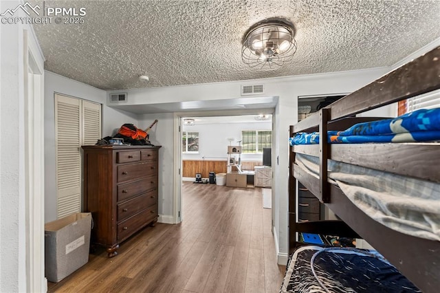 728 Squire St, Colorado Springs, CO 80911 - bedroom featuring a textured ceiling, wood finished floors, a closet, and a wainscoted wall