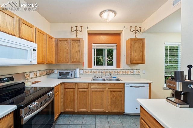 3847 Riviera Grv Unit 102, Colorado Springs, CO 80922 - kitchen featuring white appliances, plenty of natural light, and light countertops