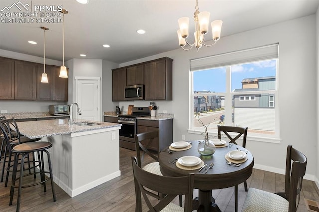 2481 Horsemanship Ct, Colorado Springs, CO 80922 - kitchen featuring stainless steel appliances, dark wood-type flooring, dark brown cabinetry, an island with sink, and recessed lighting