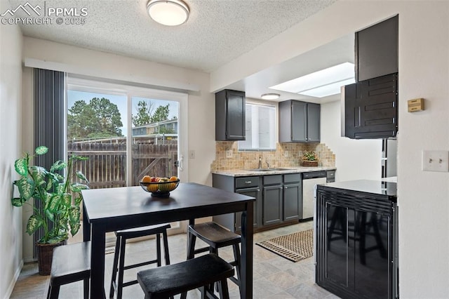 1275 Soaring Eagle Dr, Colorado Springs, CO 80915 - kitchen with dishwasher, decorative backsplash, a textured ceiling, and gray cabinets