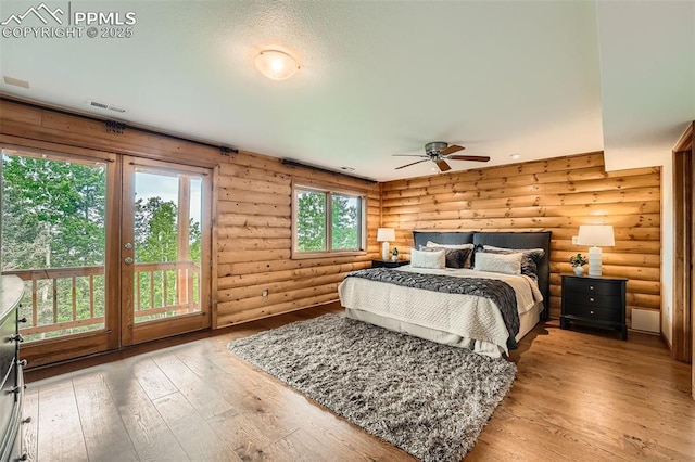 1527 S Pine Dr, Bailey, CO 80421 - bedroom with rustic walls, hardwood / wood-style floors, and access to outside