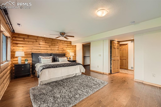 1527 S Pine Dr, Bailey, CO 80421 - bedroom with rustic walls, wood finished floors, and a ceiling fan
