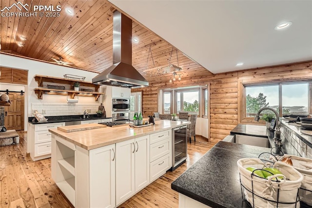 1527 S Pine Dr, Bailey, CO 80421 - kitchen with open shelves, wall chimney range hood, wine cooler, wooden counters, and lofted ceiling