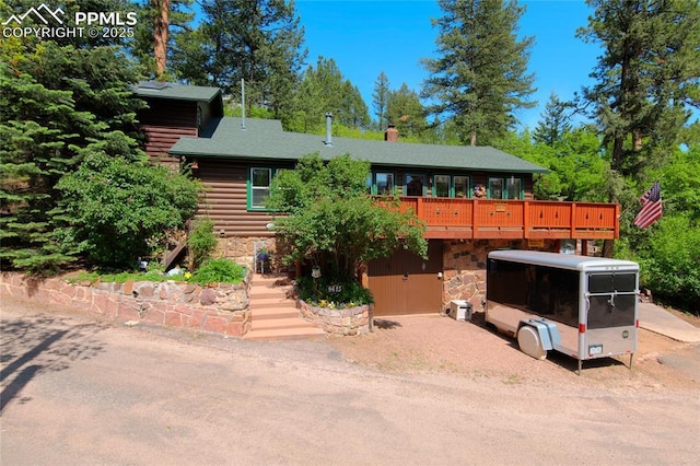 9615 Mountain Rd, Cascade, CO 80809 - view of front of home with stone siding, a deck, and log siding