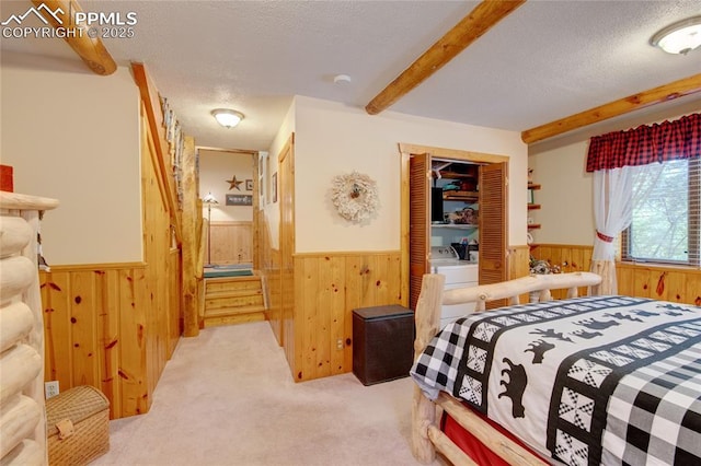 9615 Mountain Rd, Cascade, CO 80809 - carpeted bedroom with wainscoting, wooden walls, a textured ceiling, beamed ceiling, and a closet