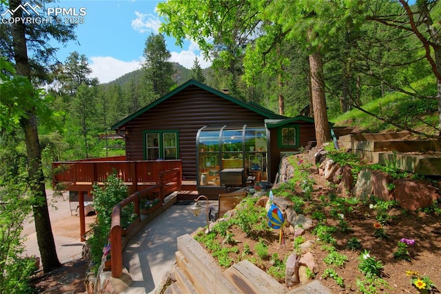 9615 Mountain Rd, Cascade, CO 80809 - back of property featuring a deck and a forest view