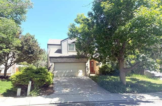 945 Marlstone Pl, Colorado Springs, CO 80904 - obstructed view of property with concrete driveway, an attached garage, and brick siding