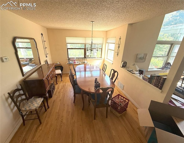 945 Marlstone Pl, Colorado Springs, CO 80904 - dining area with a textured ceiling, light wood-style floors, and a chandelier
