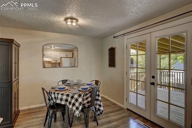 4110 Undimmed Cir, Colorado Springs, CO 80917 - dining area with french doors, wood finished floors, and a textured ceiling