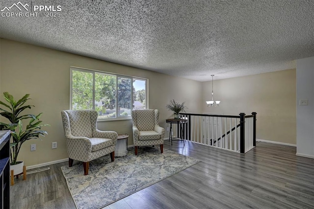 4110 Undimmed Cir, Colorado Springs, CO 80917 - sitting room with an upstairs landing, a chandelier, wood finished floors, and a textured ceiling