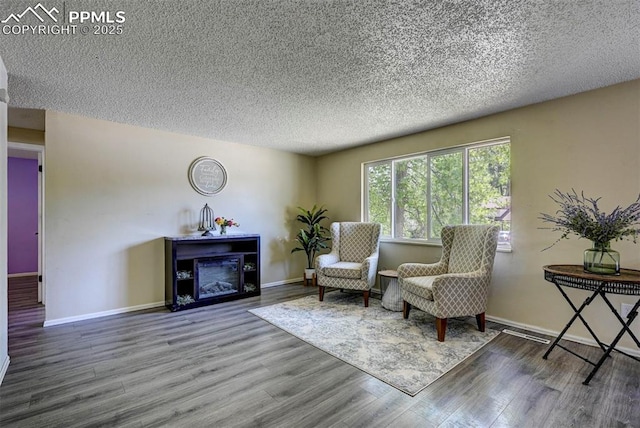 4110 Undimmed Cir, Colorado Springs, CO 80917 - sitting room with a textured ceiling, wood finished floors, and a fireplace