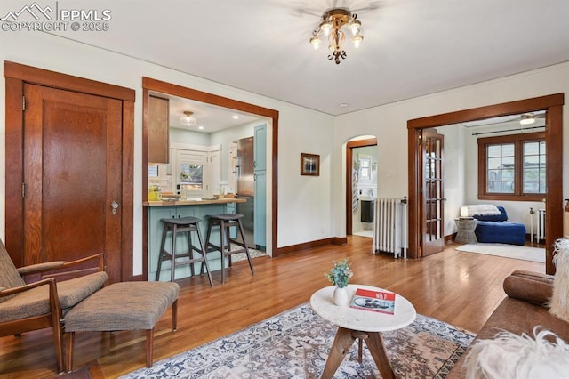 1401 N Tejon St, Colorado Springs, CO 80907 - living room featuring arched walkways, wood finished floors, and radiator heating unit
