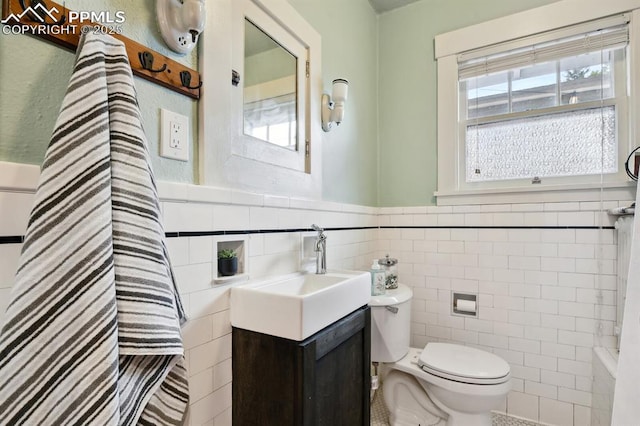 1401 N Tejon St, Colorado Springs, CO 80907 - full bathroom with tile walls, vanity, and wainscoting