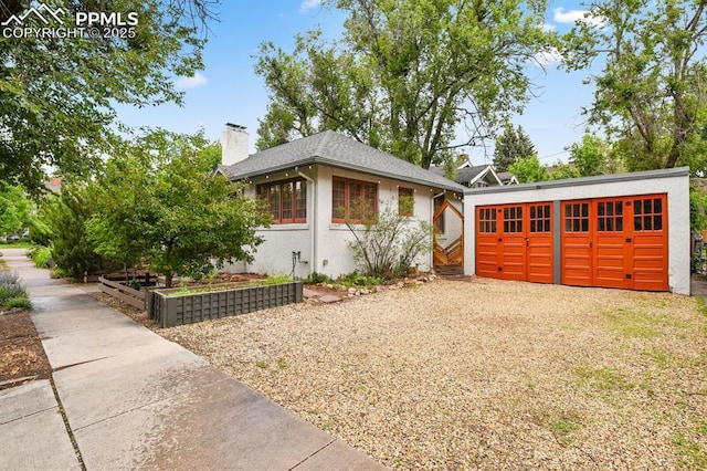 1401 N Tejon St, Colorado Springs, CO 80907 - view of front of property with a vegetable garden, a chimney, stucco siding, and an outbuilding