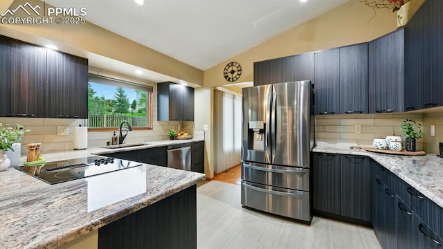 440 Torrey Pines Way, Colorado Springs, CO 80921 - kitchen featuring stainless steel appliances, vaulted ceiling, tasteful backsplash, light stone counters, and light wood-style floors