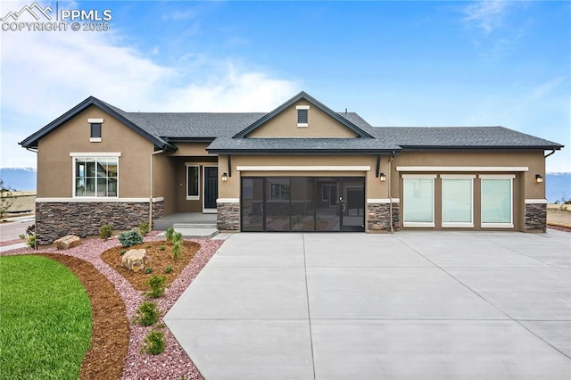 9996 Antelope Ravine Dr, Colorado Springs, CO 80908 - view of front of home featuring stone siding, stucco siding, driveway, and an attached garage