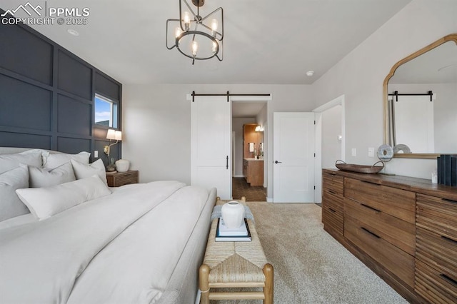 9996 Antelope Ravine Dr, Colorado Springs, CO 80908 - bedroom featuring a barn door, carpet flooring, a chandelier, and ensuite bath