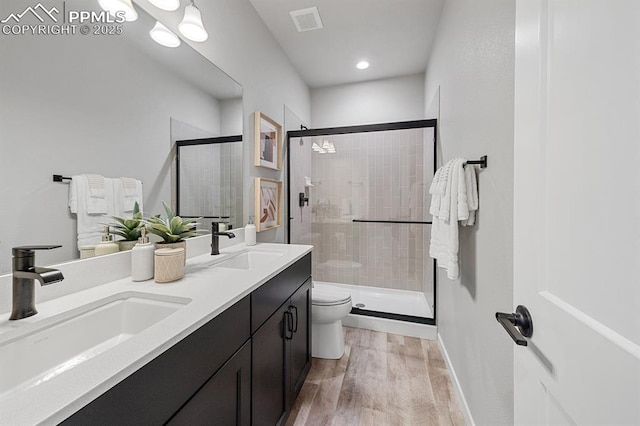 9996 Antelope Ravine Dr, Colorado Springs, CO 80908 - bathroom featuring double vanity, a shower stall, wood finished floors, and recessed lighting