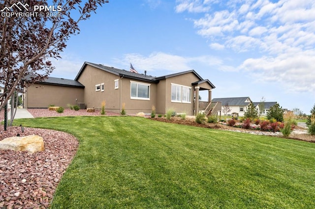 9996 Antelope Ravine Dr, Colorado Springs, CO 80908 - back of house with stucco siding and a lawn