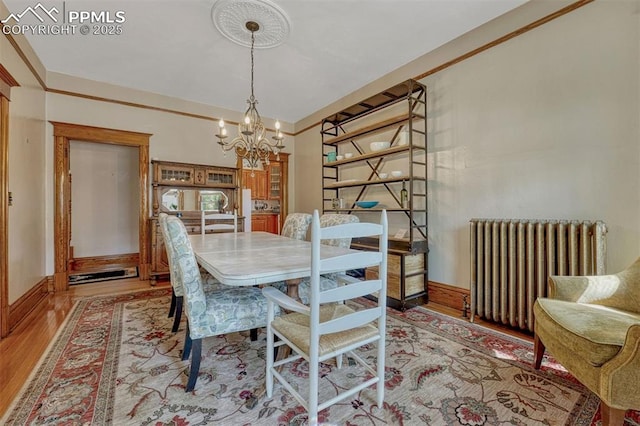 2302 W Kiowa St, Colorado Springs, CO 80904 - dining room with radiator, a chandelier, and light wood-style floors