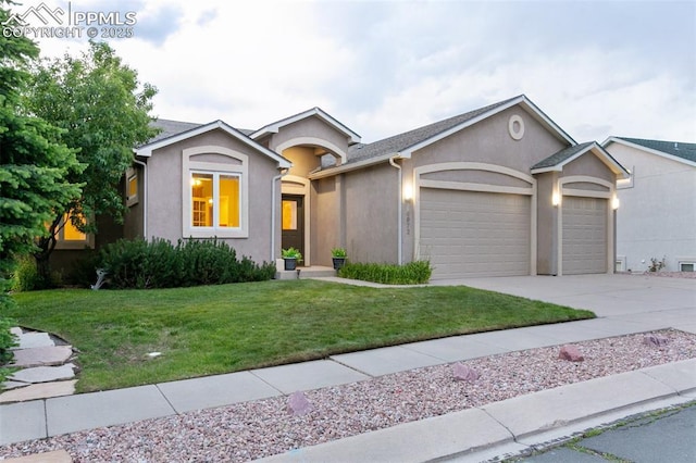 6972 Granite Peak Dr, Colorado Springs, CO 80923 - view of front of home featuring a garage, stucco siding, a front yard, and concrete driveway