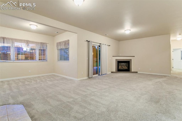 6972 Granite Peak Dr, Colorado Springs, CO 80923 - unfurnished living room featuring carpet flooring and a glass covered fireplace