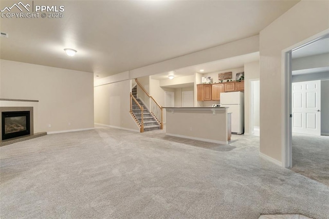 6972 Granite Peak Dr, Colorado Springs, CO 80923 - unfurnished living room with light carpet, stairway, and a glass covered fireplace