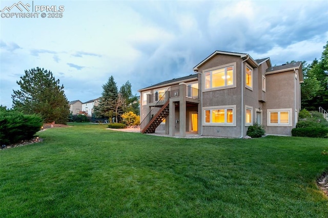 6972 Granite Peak Dr, Colorado Springs, CO 80923 - back of house with stairway, a deck, a lawn, and stucco siding