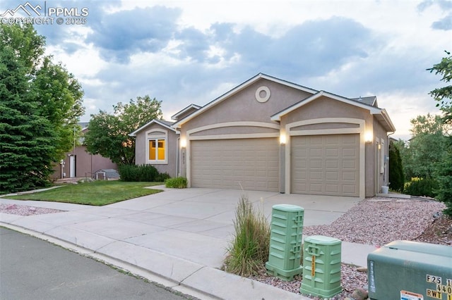 6972 Granite Peak Dr, Colorado Springs, CO 80923 - ranch-style home with concrete driveway, stucco siding, an attached garage, and a front lawn