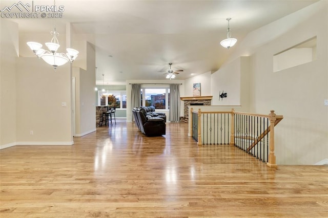 6972 Granite Peak Dr, Colorado Springs, CO 80923 - living room featuring light wood-type flooring, a ceiling fan, a fireplace, a chandelier, and vaulted ceiling