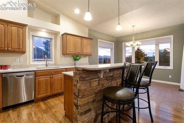 6972 Granite Peak Dr, Colorado Springs, CO 80923 - kitchen featuring dishwasher, lofted ceiling, a center island, wood finished floors, and pendant lighting