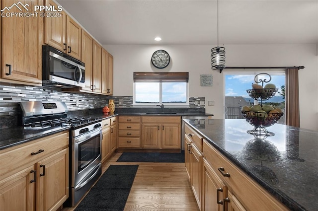 7665 Manston Dr, Colorado Springs, CO 80920 - kitchen featuring stainless steel appliances, backsplash, wood finished floors, recessed lighting, and dark stone counters