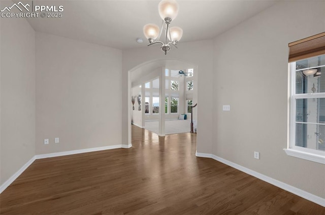 7665 Manston Dr, Colorado Springs, CO 80920 - unfurnished dining area with arched walkways, a chandelier, and dark wood finished floors