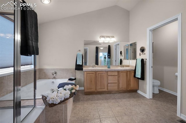 7665 Manston Dr, Colorado Springs, CO 80920 - full bath with double vanity, lofted ceiling, a garden tub, tile patterned floors, and plenty of natural light
