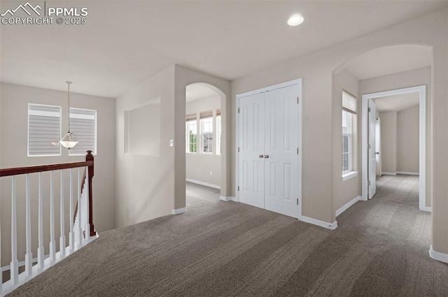 7665 Manston Dr, Colorado Springs, CO 80920 - corridor featuring arched walkways, carpet flooring, recessed lighting, and an upstairs landing