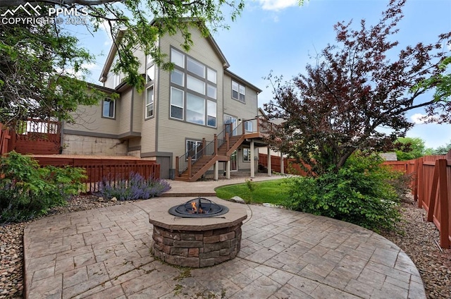 7665 Manston Dr, Colorado Springs, CO 80920 - fenced backyard with stairs, an outdoor fire pit, a patio, and a wooden deck