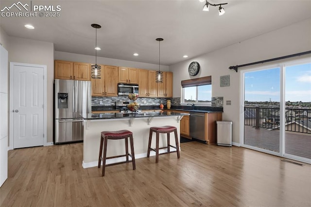 7665 Manston Dr, Colorado Springs, CO 80920 - kitchen with stainless steel appliances, dark countertops, light wood-style floors, tasteful backsplash, and recessed lighting