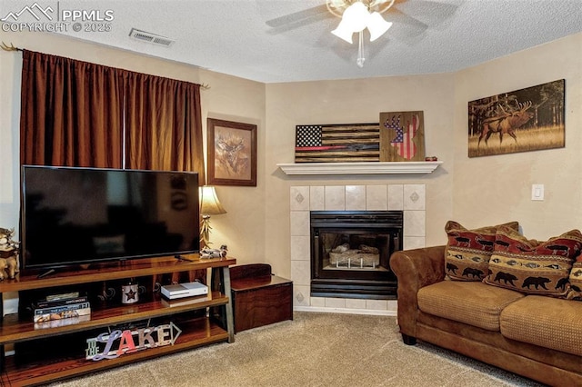 601 Harvest Field Way, Fountain, CO 80817 - living room with carpet, ceiling fan, a textured ceiling, and a tile fireplace