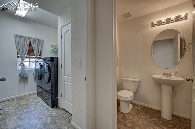 9444 Castle Oaks Dr, Fountain, CO 80817 - bathroom with washing machine and dryer and toilet