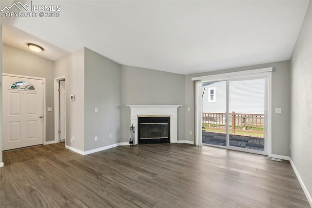 4680 Pika Pt, Colorado Springs, CO 80922 - unfurnished living room with dark wood-style flooring and a glass covered fireplace