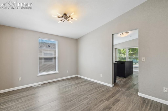4680 Pika Pt, Colorado Springs, CO 80922 - empty room with wood finished floors, a chandelier, and vaulted ceiling